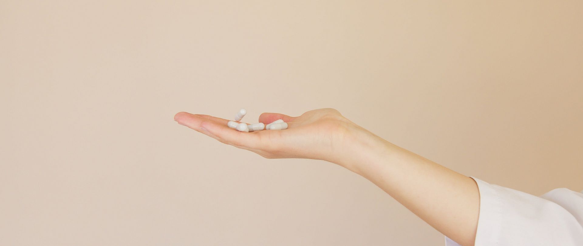 person holding white pills