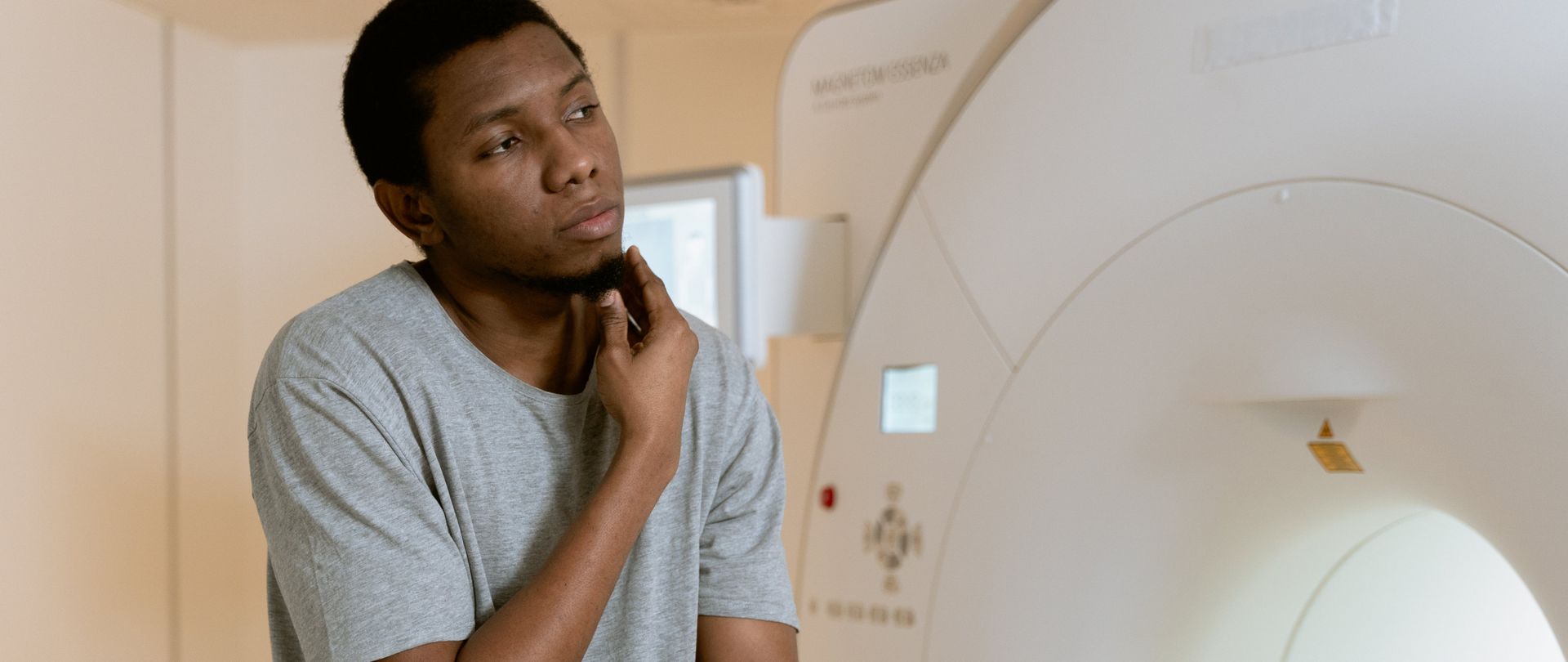 man sitting near CT scanner