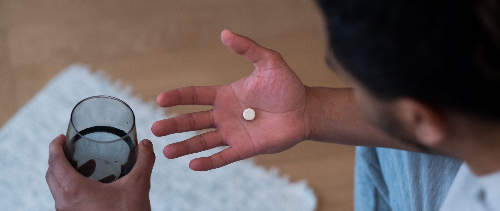 man holding pill and water